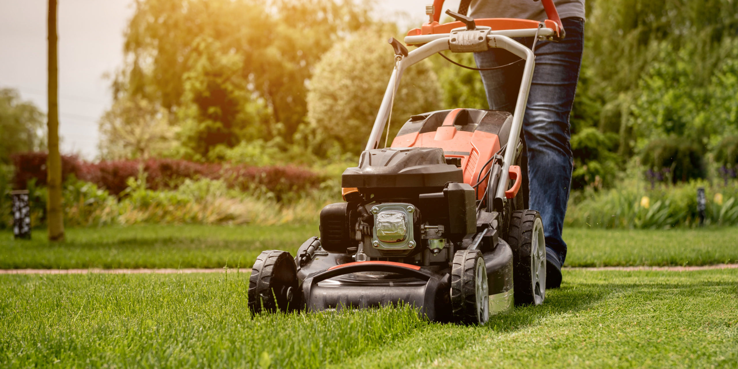 Gardener mowing the lawn. Landscape design.